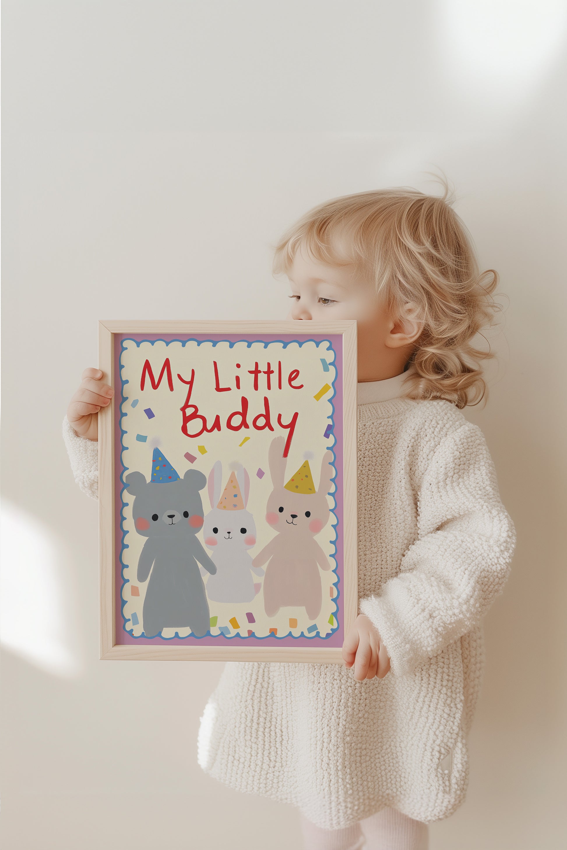 Ein Kind hält das fröhliche Poster 'My Little Buddy' von justgoodmood, das einen Bären und Hasen mit Partyhüten zeigt, perfekt als Geschenkidee.