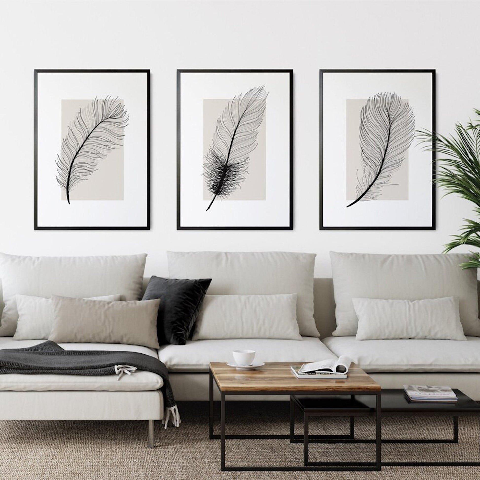 Elegantes Poster Schwarze Feder als Deko Print ohne Rahmen von justgoodmood, präsentiert in einem modernen Wohnzimmer mit einem hellen Sofa.