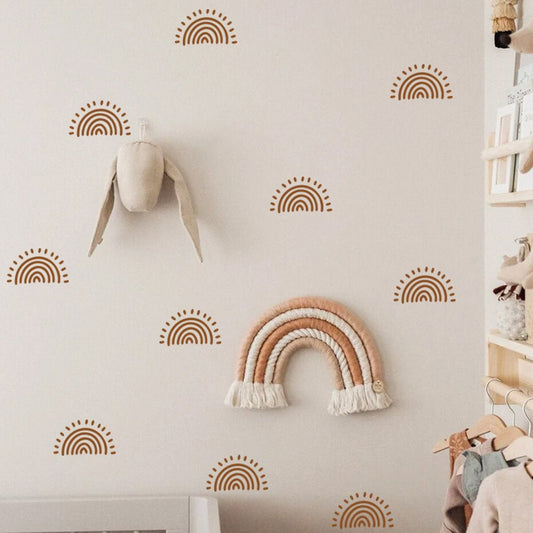 Motiv von Wandaufklebern für Kinderzimmer Sonnenschein im Boho Stil von justgoodmood, gezeigt mit süßem Spielzeug und charmanten Regenbogen-Dekorationen.