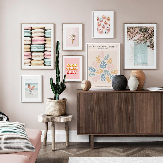 Bunte Wanddekoration mit verschiedenen Postern, darunter das stilvolle Poster von justgoodmood mit Macarons und einer Avocado als Deko Print ohne Rahmen, ideal zur Verschönerung Ihres Wohnraums.