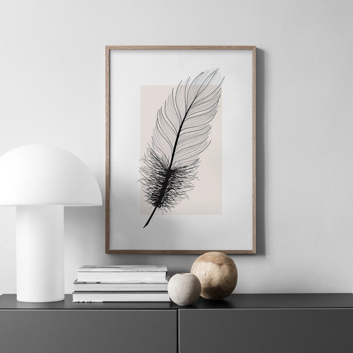 Stilvolles Poster Schwarze Feder als Deko Print ohne Rahmen von justgoodmood, dekoriert mit einer stilvollen Lampe und Wohnaccessoires.
