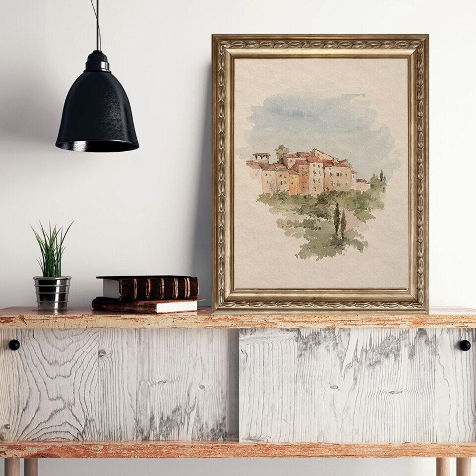 Wunderschöner Druck Aquarell Marokkanische Architektur von justgoodmood, stilvoll gerahmt und platziert in einer modernen Einrichtung mit Pflanzen und Büchern.