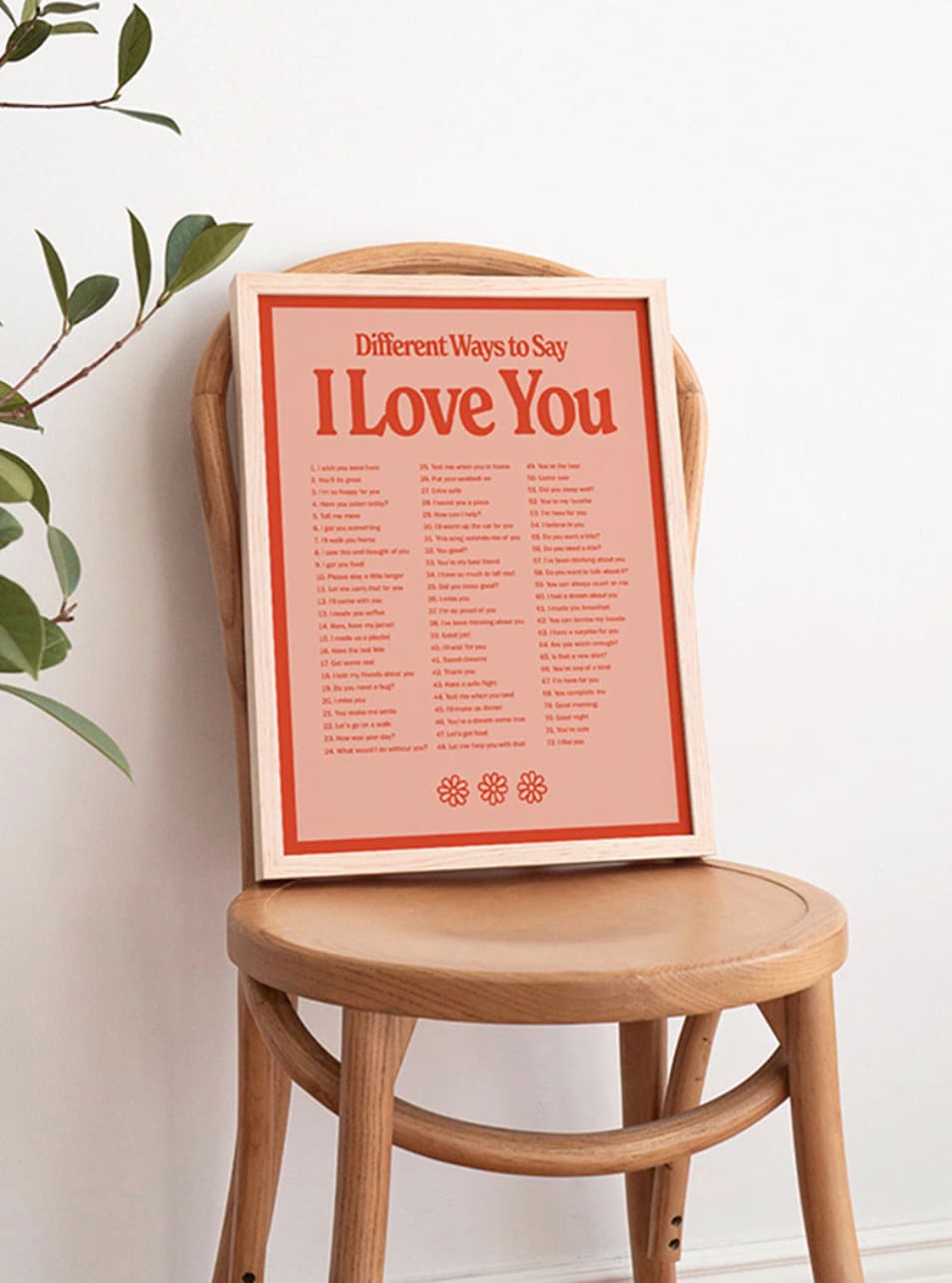 Stylisches Valentinstag-Poster "Ich liebe Dich" von justgoodmood, das verschiedene Wege zeigt, Liebe auszudrücken, stilvoll auf einem Holzstuhl präsentiert.