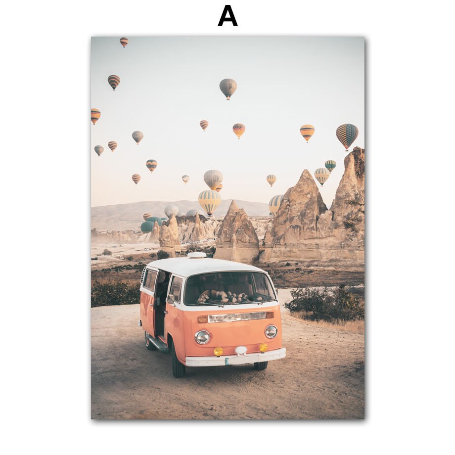 Blick auf das Poster 'Strand Burg Heißluftballon Kappadokien' von justgoodmood. Ein charmantes orangefarbenes Volkswagen-Bus vor einer malerischen Landschaft mit Heißluftballons im Himmel, ideal für jede Wandgestaltung.