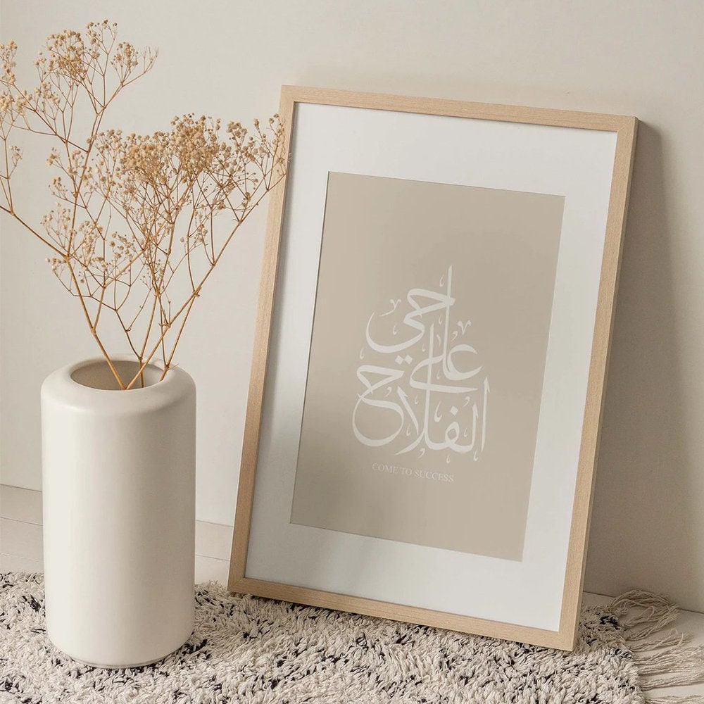 Schönes Poster mit islamischer Kalligraphie von justgoodmood, stilvoll gerahmt neben einer eleganten Vase mit Trockenblumen.