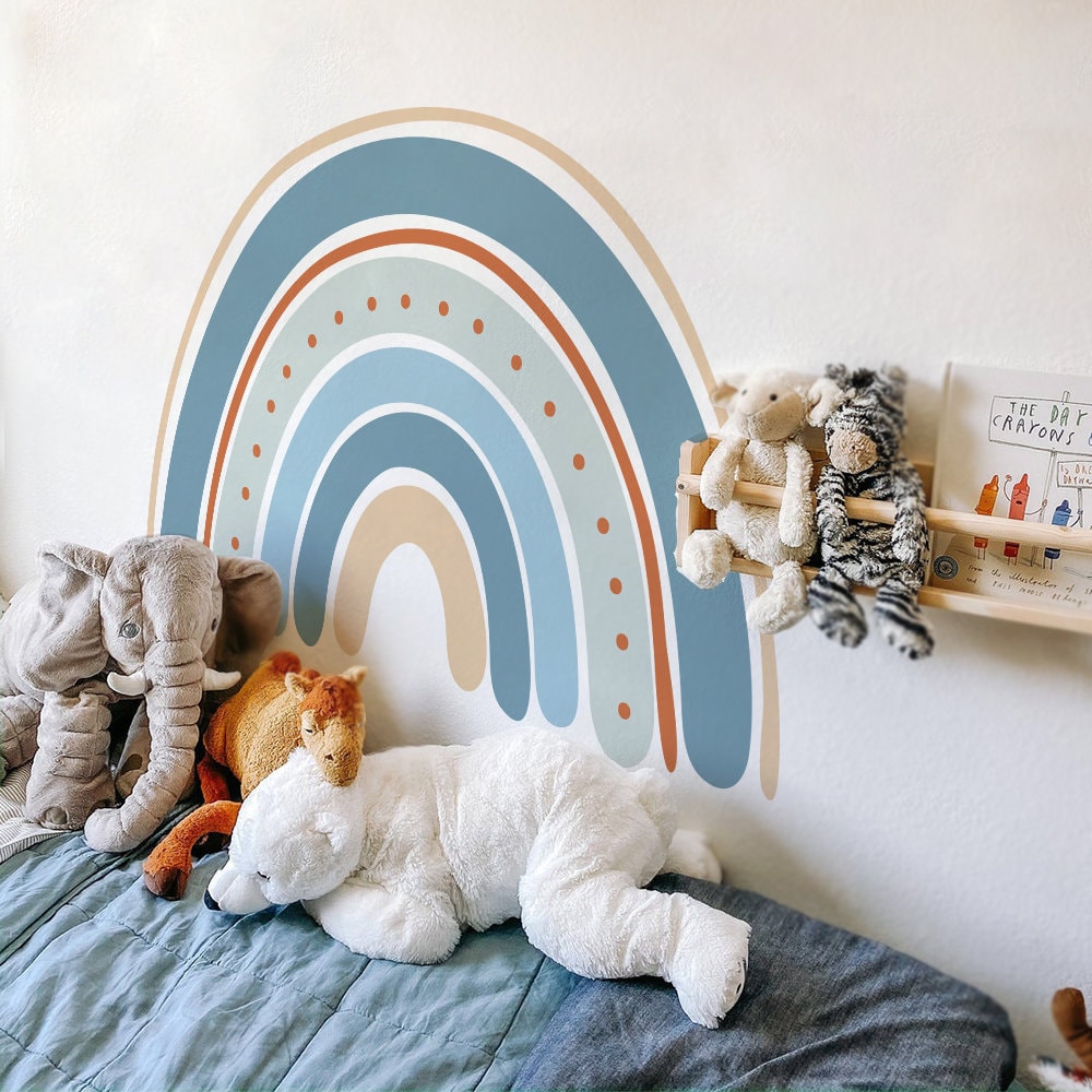 Bunter Boho-Stil Regenbogen Wandaufkleber von justgoodmood im Kinderzimmer, umgeben von Kuscheltieren, ideal für die Wanddekoration in einem Babyzimmer.