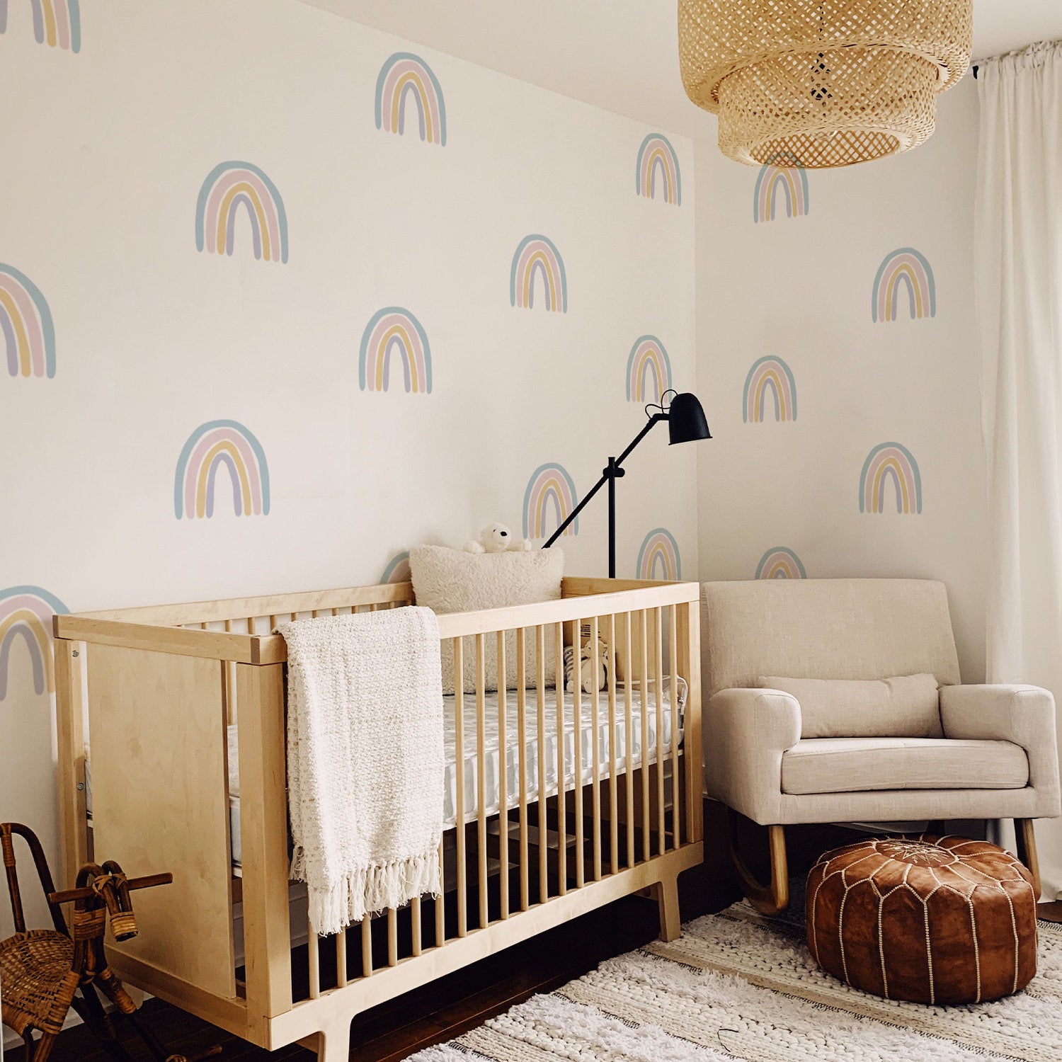 Fantasievolle Wanddekoration mit Boho Regenbogen Wandaufkleber von justgoodmood in einem hellen Kinderzimmer. Das Bild zeigt ein modernes Babyzimmer mit einem Holzbett, sanften Farben und niedlichen Regenbogenmotiven an der Wand, perfekt für kreative Kinder.