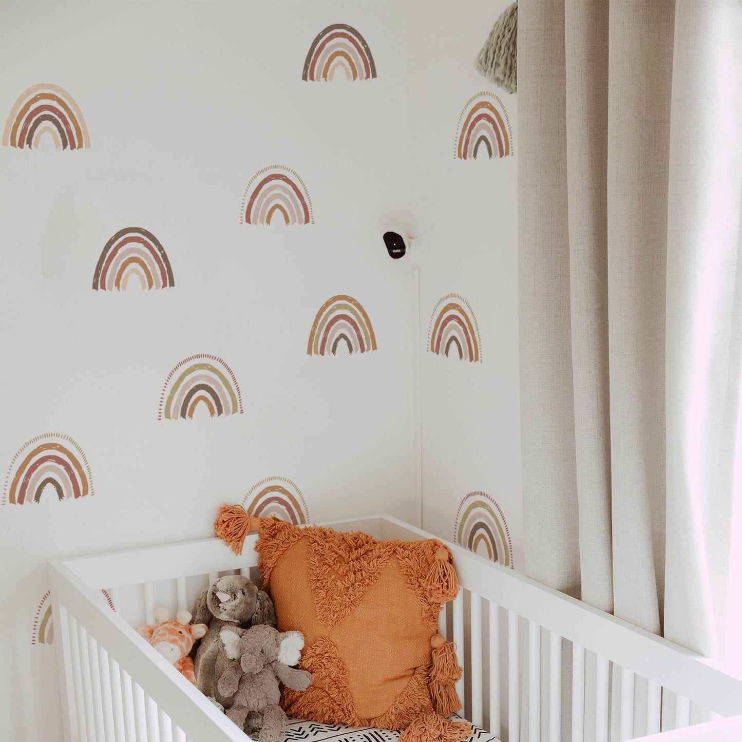 Boho Regenbogen Wandaufkleber von justgoodmood, fröhliche Wanddeko im Kinderzimmer mit bunten Regenbogenmotiven und einem kuscheligen Kinderbett.