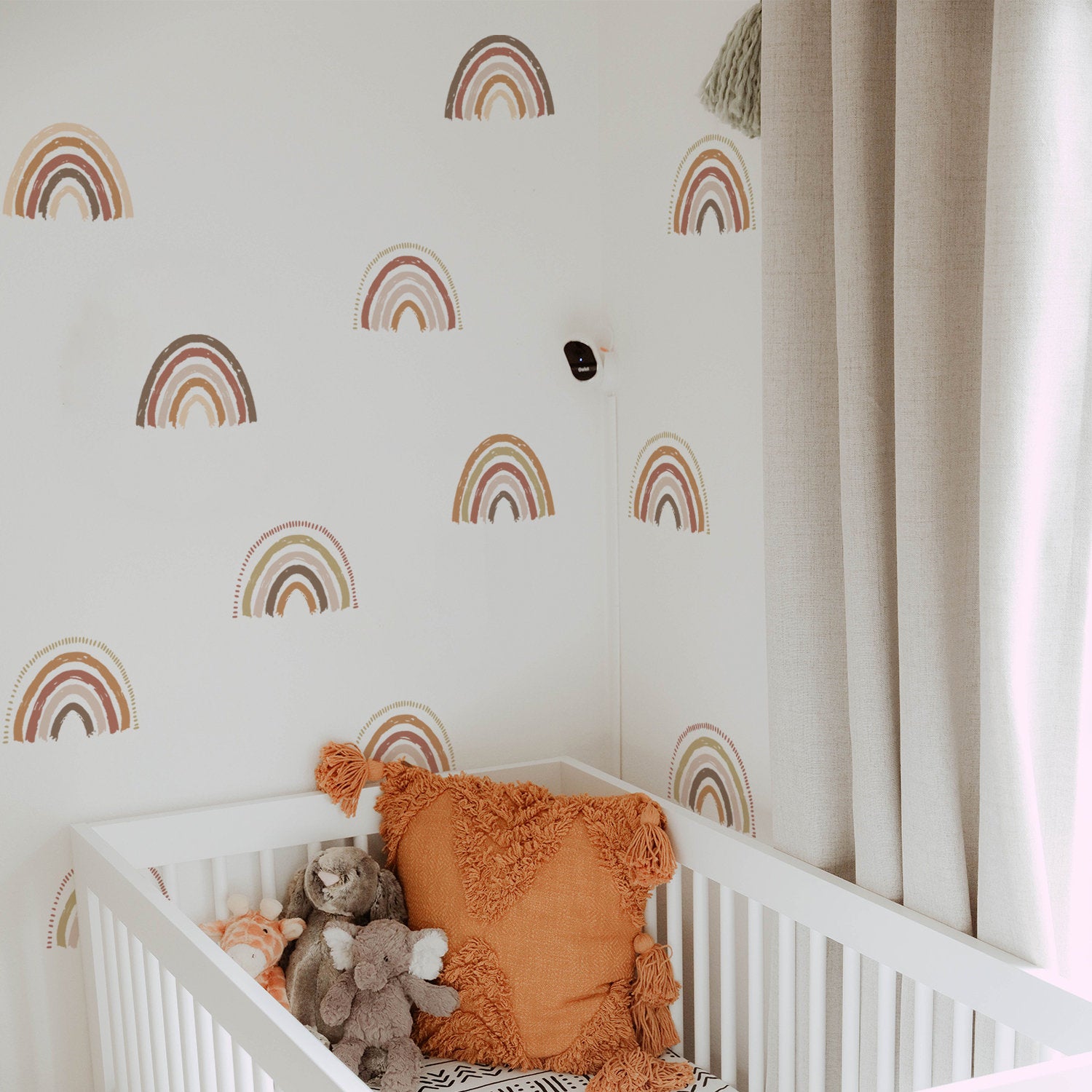 Boho Regenbogen Wandaufkleber von justgoodmood, fröhliche Wanddeko im Kinderzimmer mit bunten Regenbogenmotiven und einem kuscheligen Kinderbett.