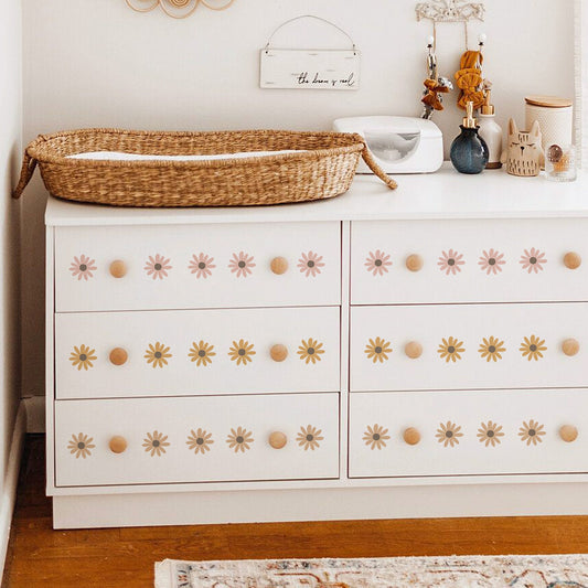 Stylische Wickelkommode mit Boho Blumen Wandtattoos von justgoodmood. Die süßen Wandaufkleber bringen Freude ins Kinderzimmer und setzen farbenfrohe Akzente auf der weißen Möbeloberfläche.