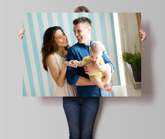 Ein glückliches Paar mit einem Baby hält ein großes personalisiertes Poster, das perfekt zu ihrem modernen Zuhause passt, von justgoodmood.