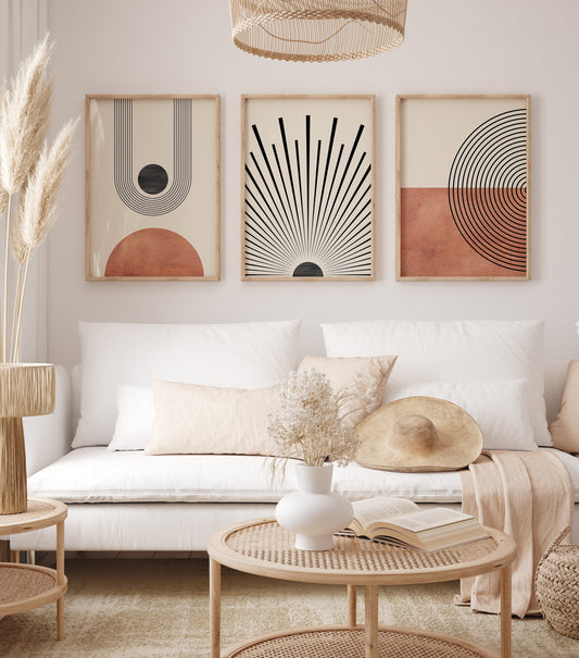 Gemütlicher Raum mit Mid Century Moderne Wandkunst im Boho Stil von justgoodmood. Drei elegante Kunstdrucke in sanften Orangetönen und Schwarz, perfekt für das moderne Zuhause.