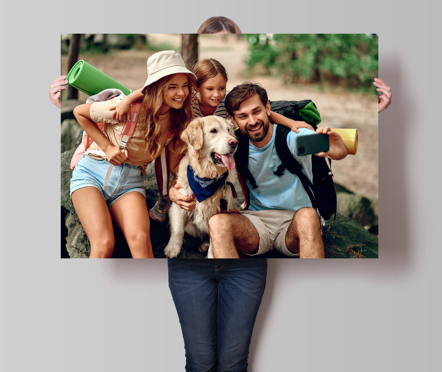 Eine fröhliche Familie posiert mit einem großen kunterbunten Poster von justgoodmood, das perfekt für Abenteuerlustige ist.