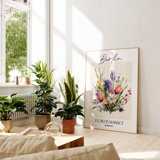Berlin Flower Market Germany Design Poster von justgoodmood, elegant auf dem Boden neben einem gemütlichen Sofa und mehreren Pflanzen platziert. Ideal für eine helle und einladende Wohnatmosphäre.