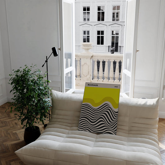 Hell und freundlich wirkendes Bauhaus Ausstellung Poster auf einem Sofa mit Blick auf eine schöne Aussicht. Perfekte Wanddeko von justgoodmood!