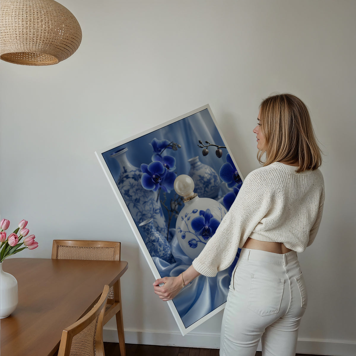 Motiv mit einem weiß-blauen Parfumflakon zwischen blauen Orchideen und Porzellanvasen, über einem Bett im hellen Schlafzimmer.