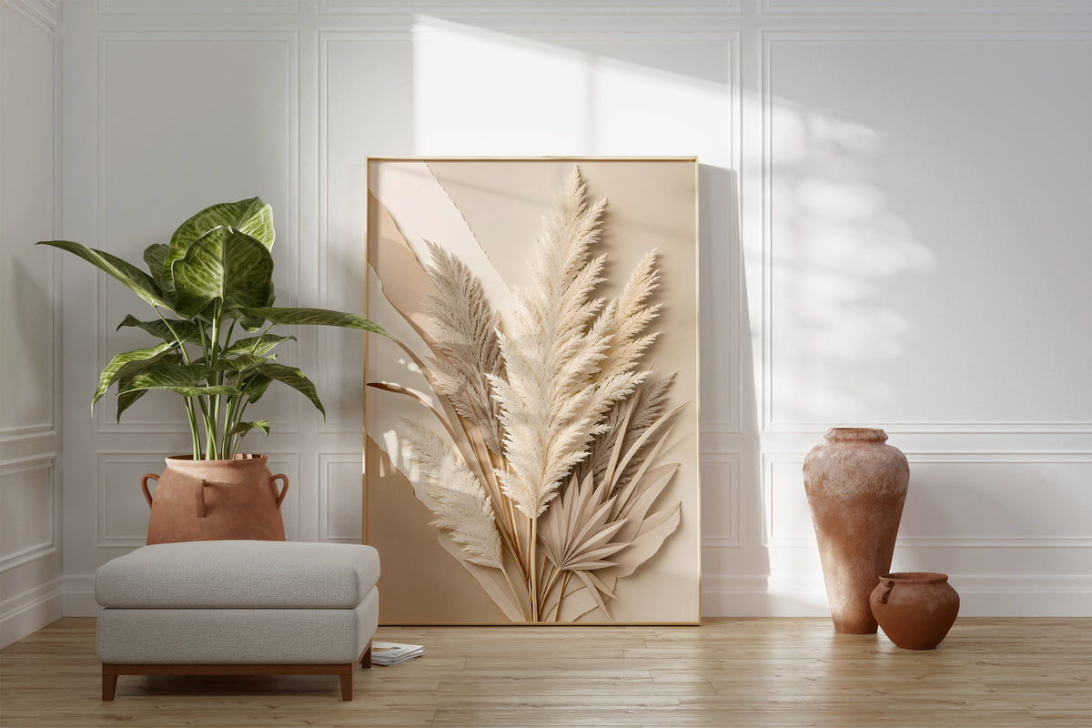 Motiv mit cremefarbenen Pampaswedeln und Palmblättern in plastischer Papierreliefoptik, als gerahmtes Poster neben Sessel und Zimmerpflanze.