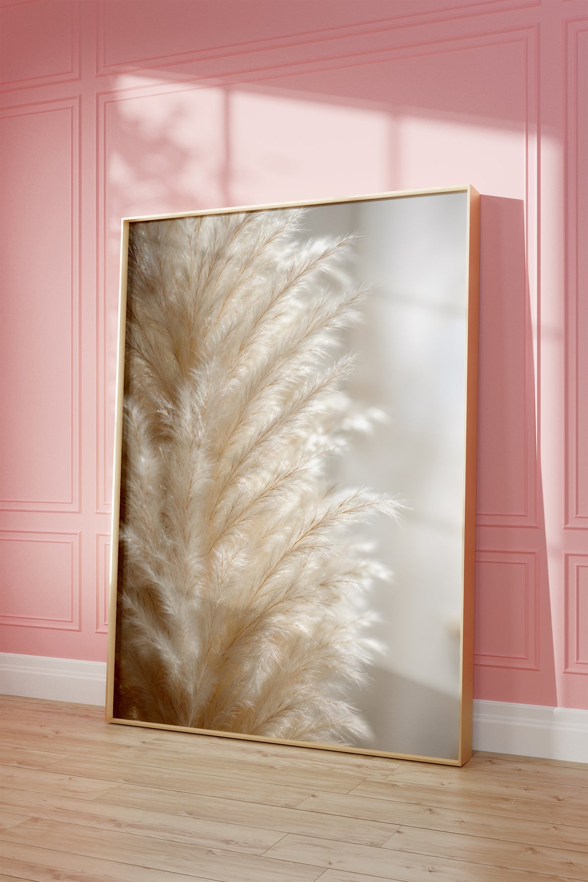 Motiv mit einer Nahaufnahme eines cremeweißen flauschigen Pampaswedels, als gerahmtes Poster vor einer rosafarbenen Wand.