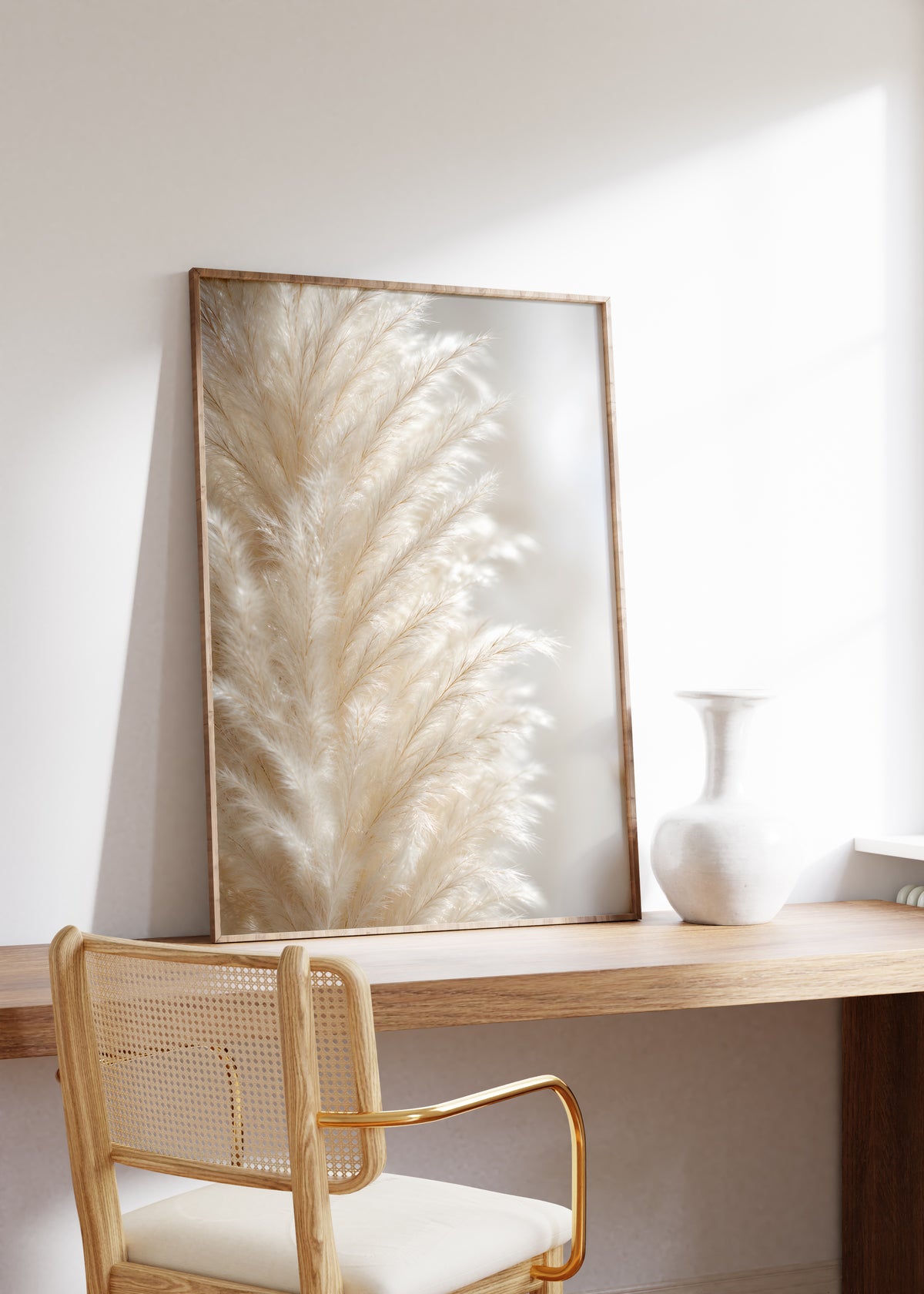 Gerahmtes Poster mit einer Nahaufnahme eines cremeweißen flauschigen Pampaswedels, auf einem Holztisch neben einer weißen Vase.