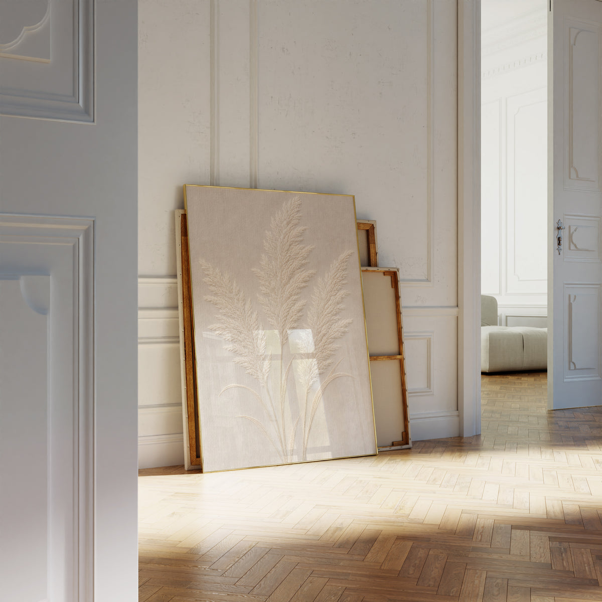 Motiv mit drei cremeweißen Pampaswedeln in Reliefoptik auf beigefarbenem Hintergrund, als an die Wand gelehntes Poster neben leeren Rahmen.