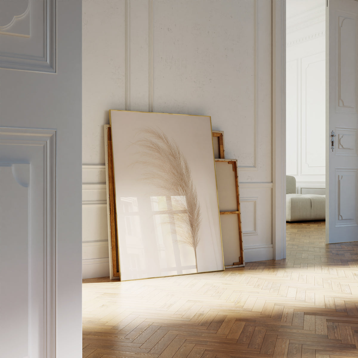 Motiv mit einem einzelnen flauschigen Pampaswedel in Cremebeige vor hellem Hintergrund, als an die Wand gelehntes Poster neben leeren Rahmen.