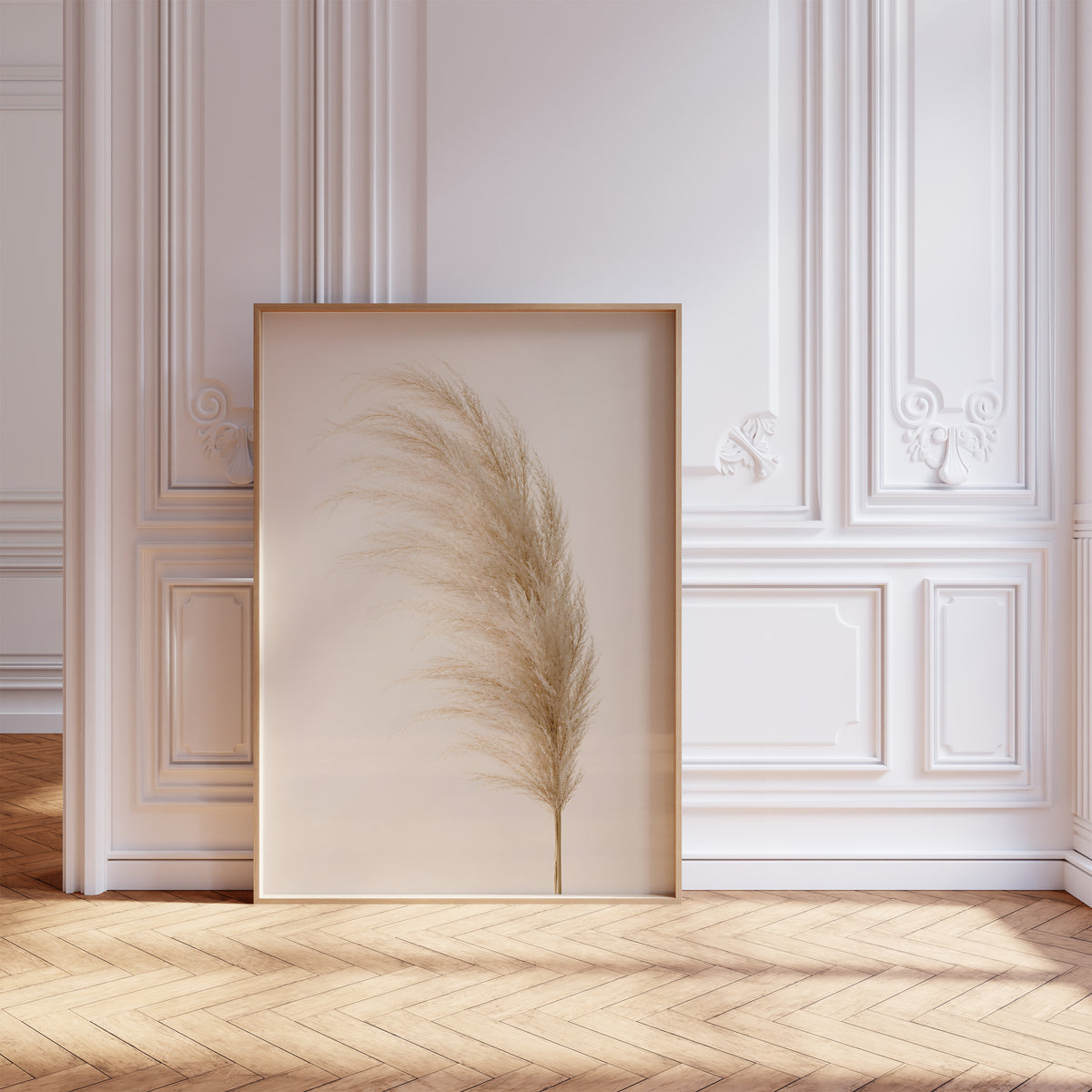 Gerahmtes Poster mit einem einzelnen flauschigen Pampaswedel in Cremebeige vor hellem Hintergrund, vor einer weißen Wand mit Zierleisten.