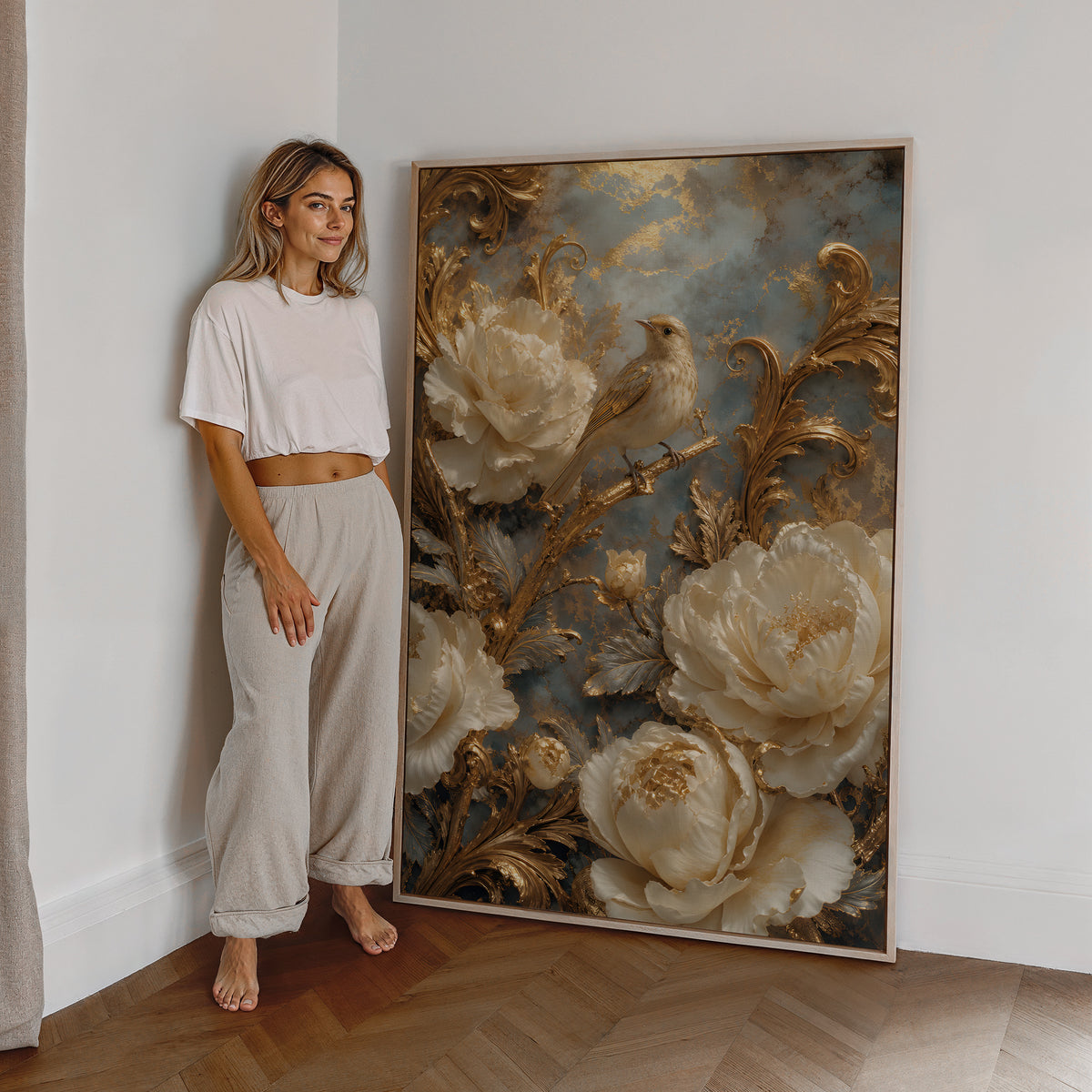 Motiv mit einem cremefarbenen Vogel zwischen weißen Blüten und goldenen Ranken, als großes gerahmtes Wandbild neben einer Frau.