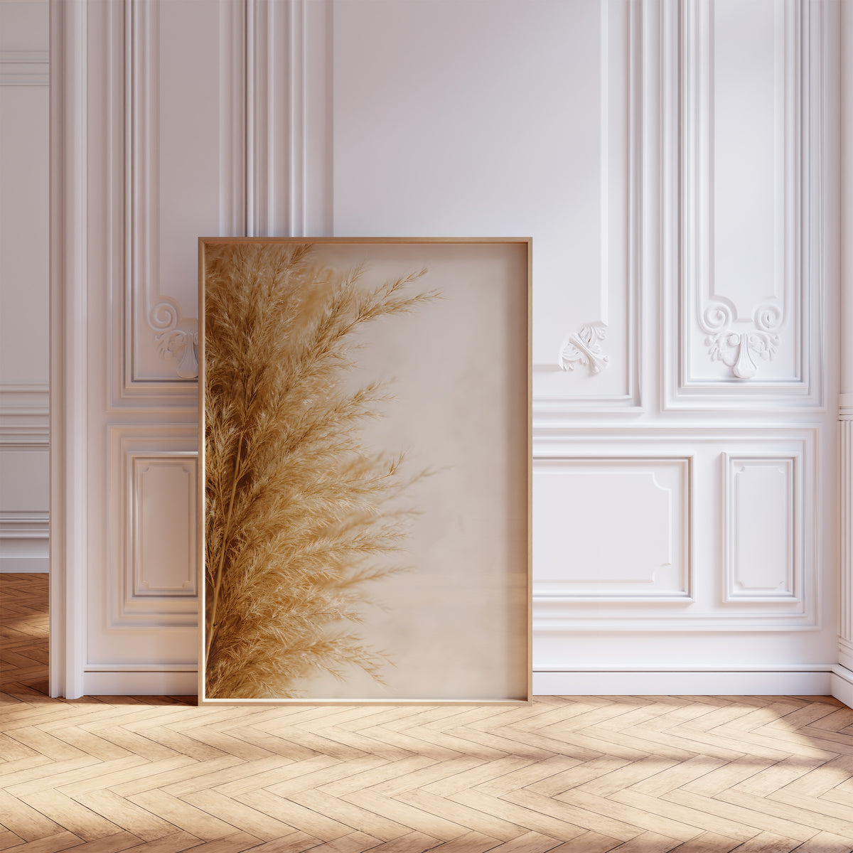Gerahmtes Poster mit goldbeigen Pampasfasern am linken Rand vor hellem Hintergrund, vor einer weißen Wand mit Zierleisten.