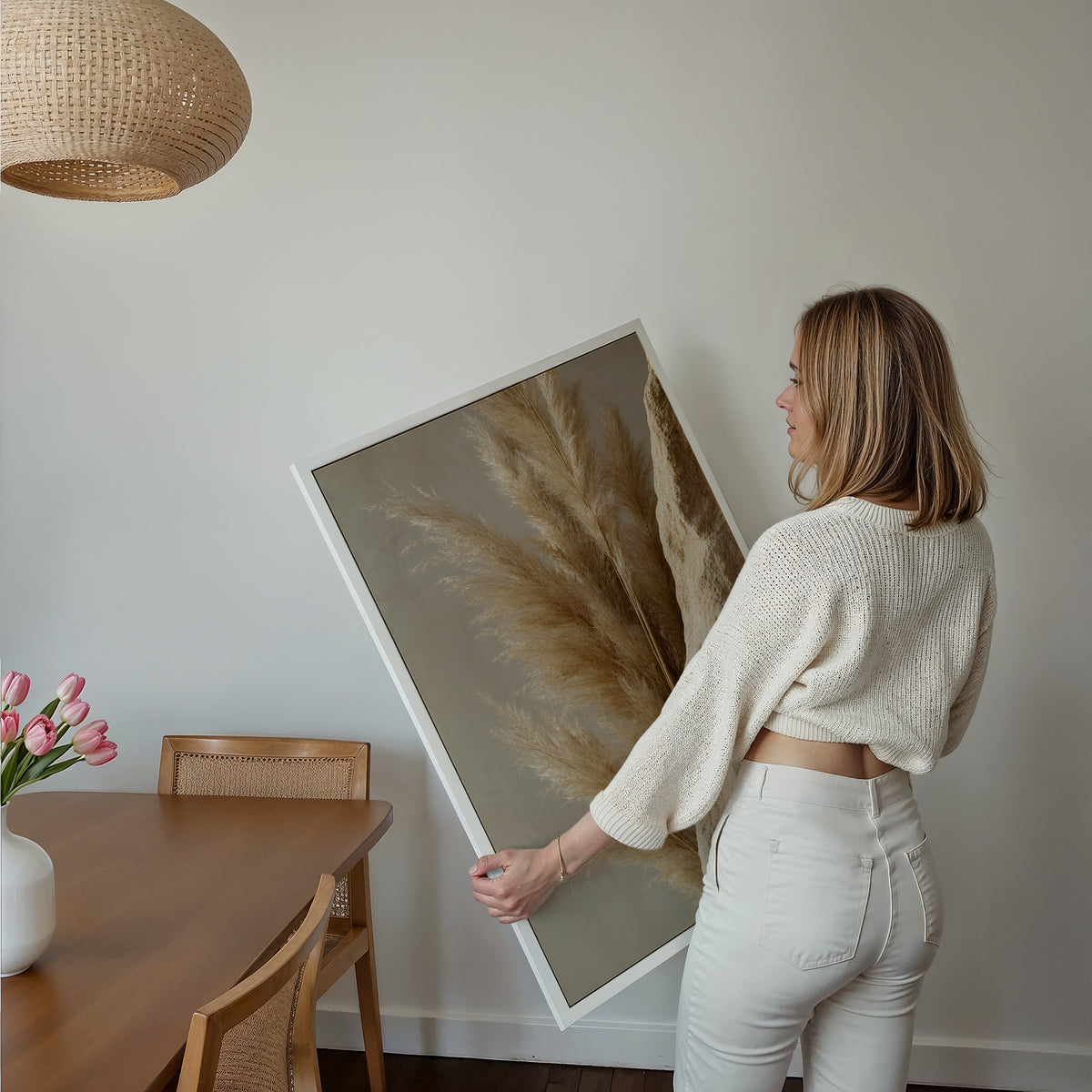 Motiv mit goldbraunen Pampaswedeln neben einer rauen sandfarbenen Steinfläche, über einem Bett im hellen Schlafzimmer.