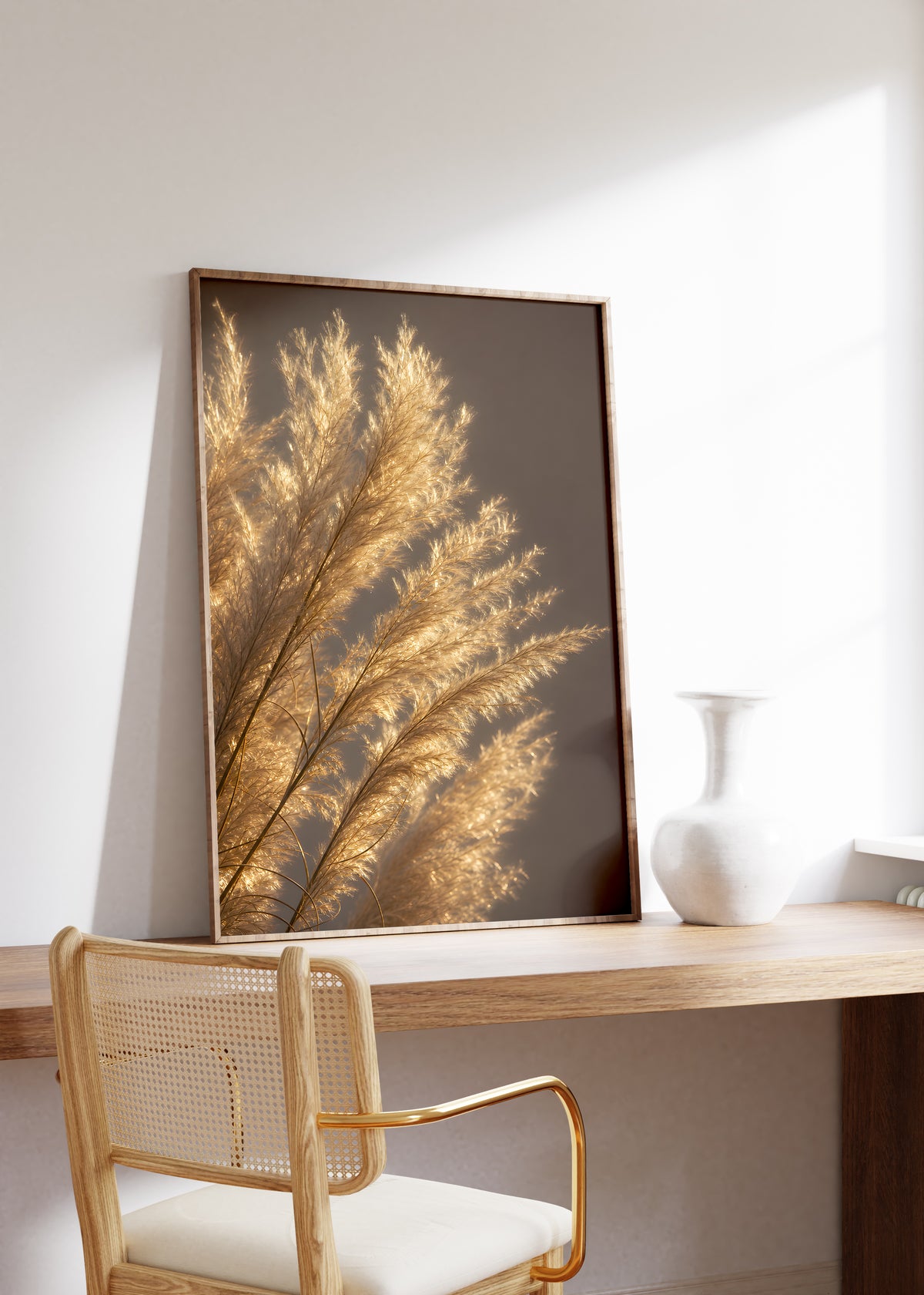 Gerahmtes Poster mit golden beleuchteten feinen Pampasfasern vor dunklem Hintergrund, auf einem Holztisch neben einer weißen Vase.