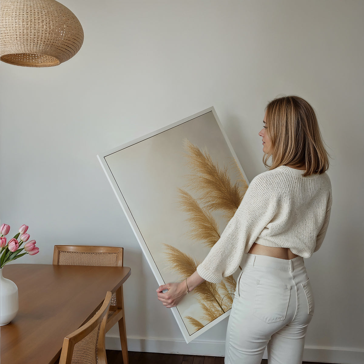 Motiv mit goldenen Pampasgräsern im hellen Gegenlicht, über einem Bett im hellen Schlafzimmer.