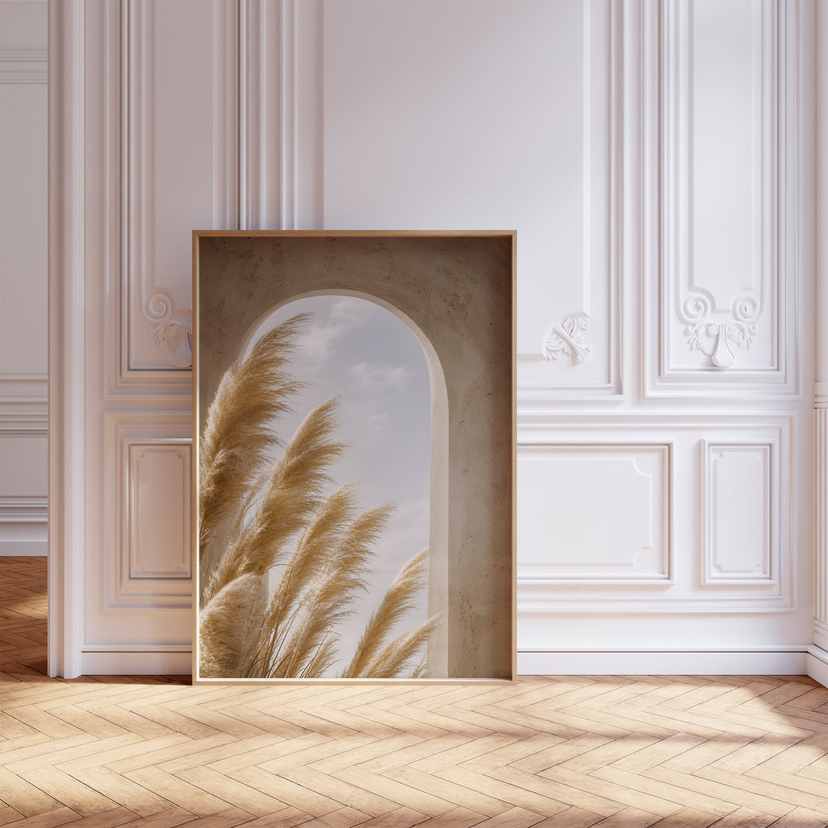 Gerahmtes Poster mit goldenen Pampaswedeln vor einem sandfarbenen Rundbogen mit Blick zum Himmel, vor einer weißen Wand mit Zierleisten.