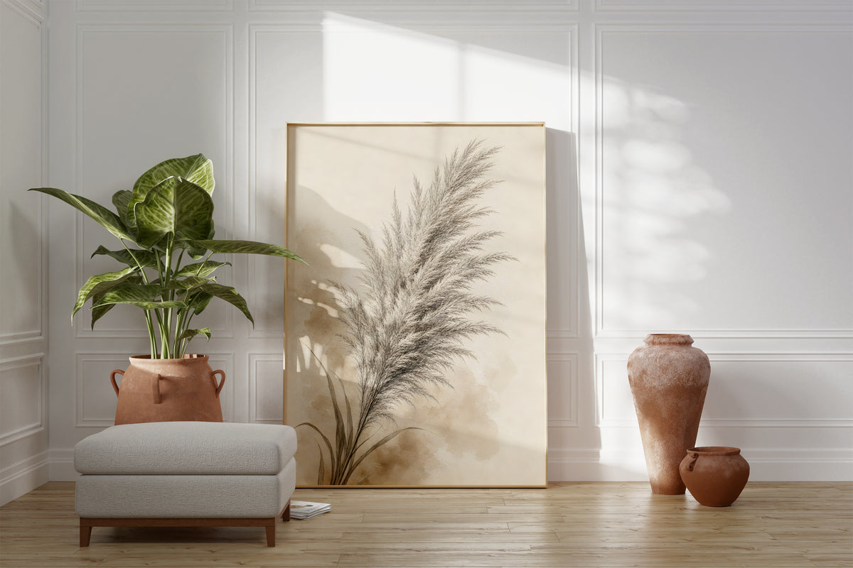 Motiv mit einem grauen Pampaswedel mit zarten beigen Aquarellflächen, als gerahmtes Poster neben Sessel und Zimmerpflanze.