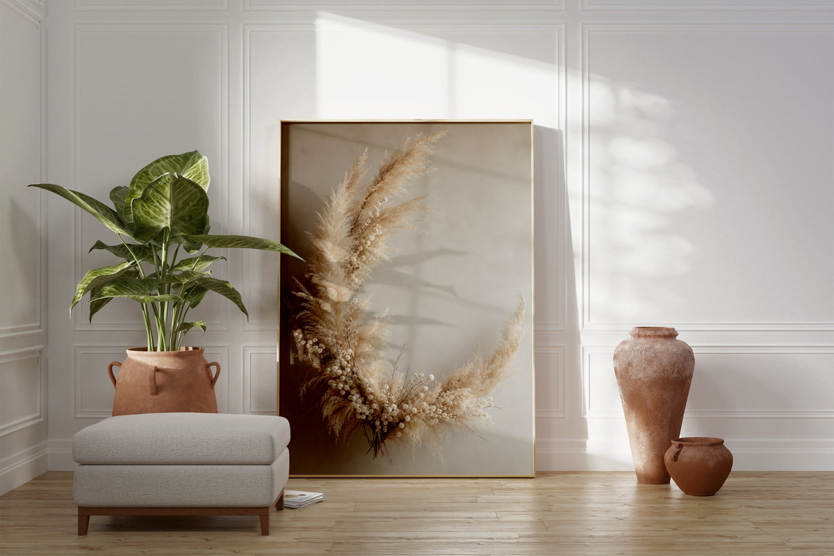 Motiv mit einem halbmondförmigen Arrangement aus Pampasgras und kleinen hellen Trockenblumen, als gerahmtes Poster neben Sessel und Zimmerpflanze.