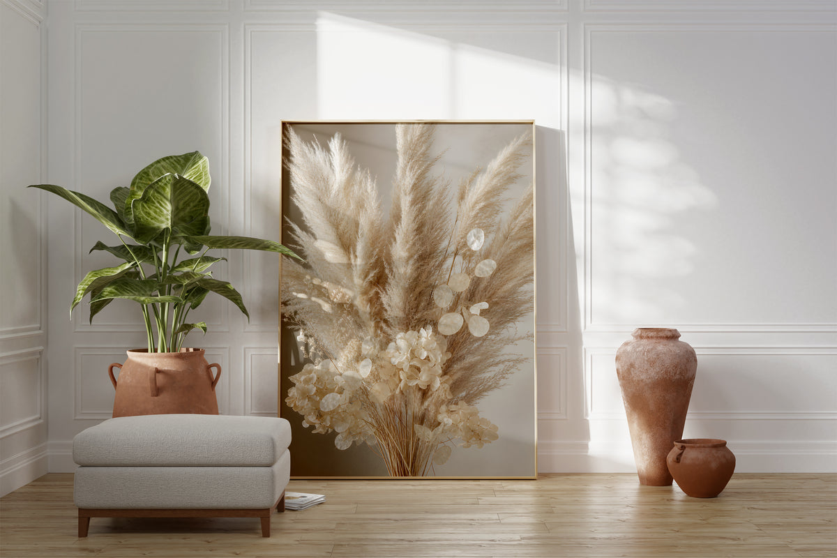 Motiv mit einem cremeweißen Bouquet aus Pampasgras, Silberblatt und hellen Blüten, als gerahmtes Poster neben Sessel und Zimmerpflanze.