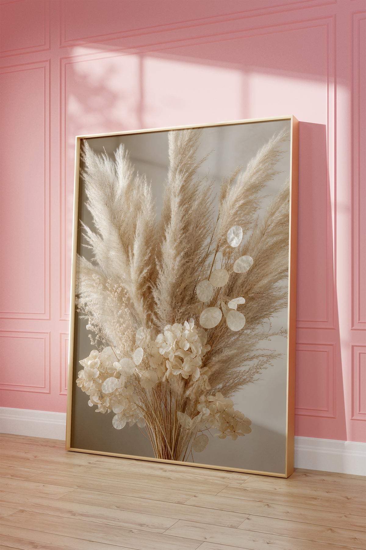 Motiv mit einem cremeweißen Bouquet aus Pampasgras, Silberblatt und hellen Blüten, als gerahmtes Poster vor einer rosafarbenen Wand.