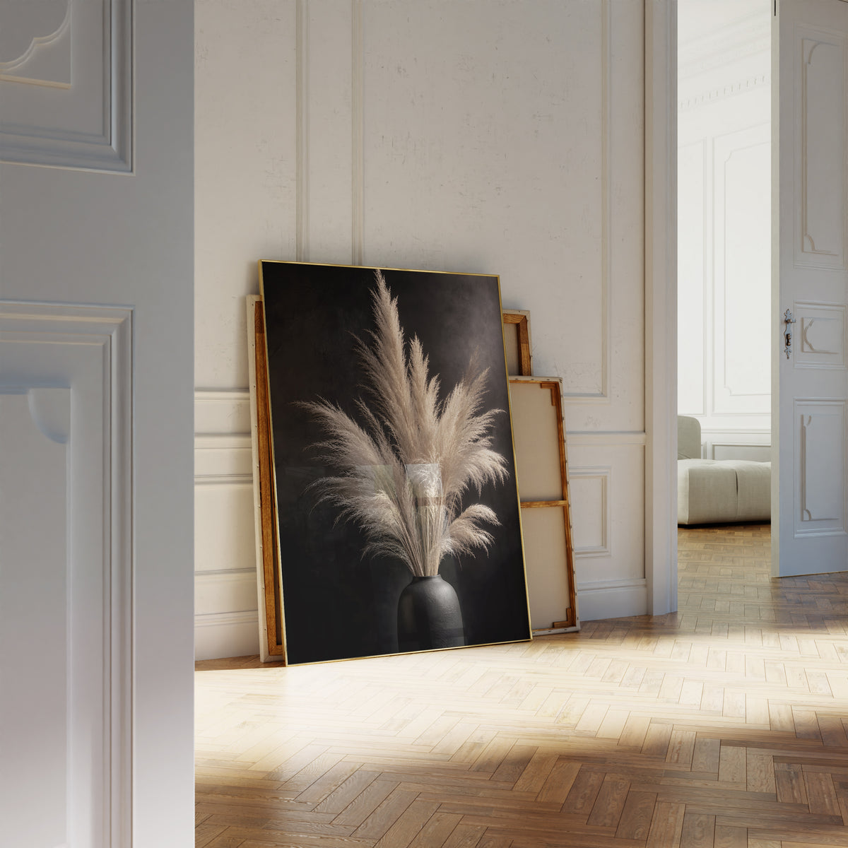 Motiv mit einem hellen Pampasbouquet in einer schwarzen Vase vor schwarzem Hintergrund, als an die Wand gelehntes Poster neben leeren Rahmen.