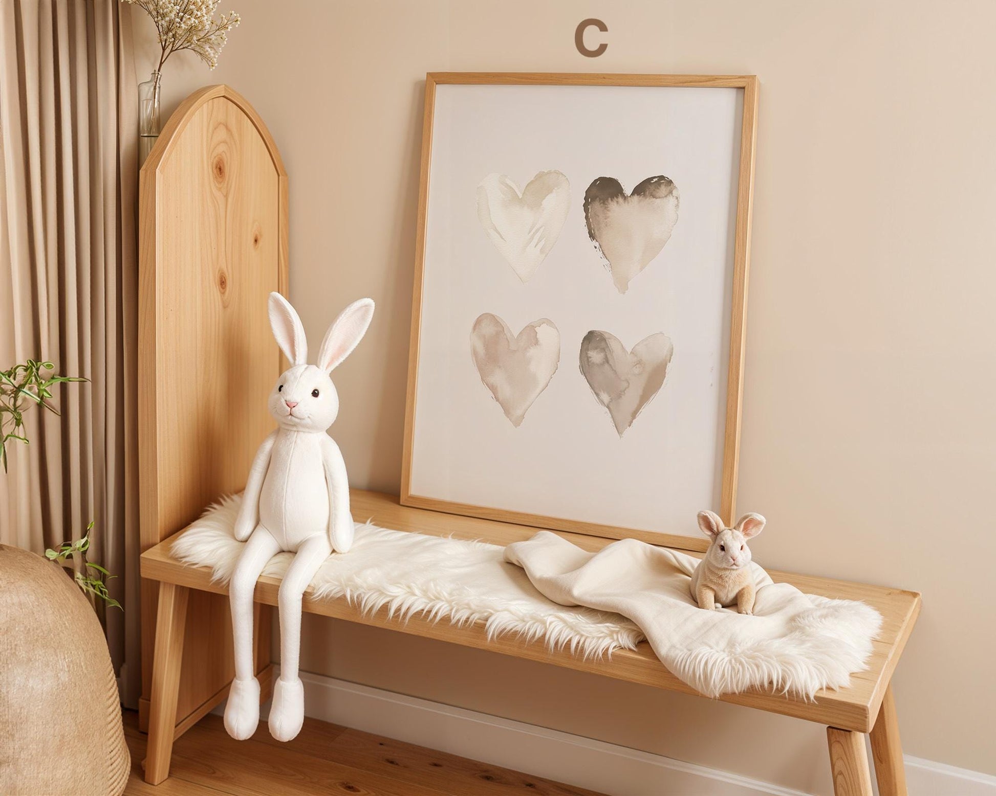Süße Hasen Poster Kinderzimmer von JUSTGOODMOOD, präsentiert in einem schönen Raum mit einer weißen Hasenpuppe auf einer Holzbank sowie einem Kunstwerk mit Herzmotiven an der Wand.
