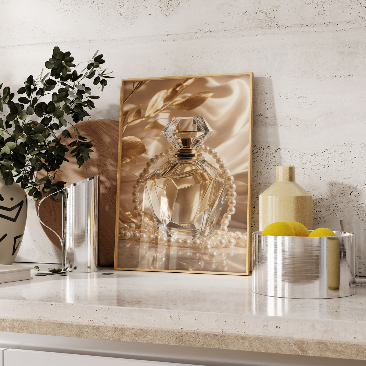 Gerahmtes Poster mit einem goldfarbenen Kristall-Parfumflakon mit Perlenkette auf Satin, auf einer Küchenarbeitsplatte neben Pflanzen und Zitronen.