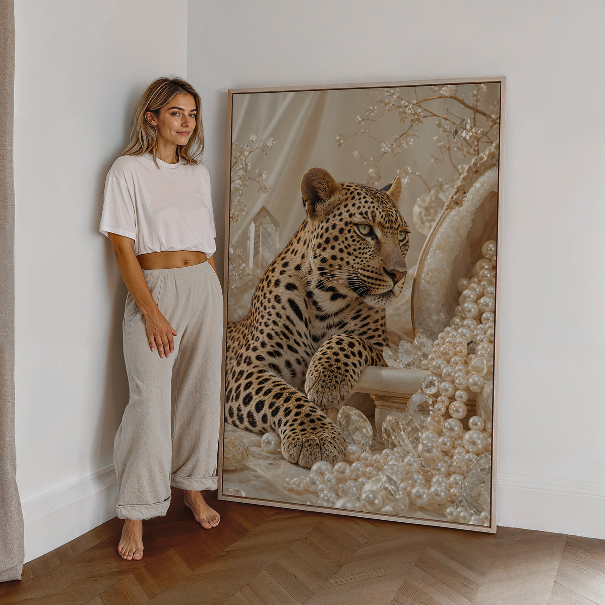 Motiv mit einem Leoparden zwischen cremefarbenen Perlen und goldenen Zweigen, als großes gerahmtes Wandbild neben einer Frau.