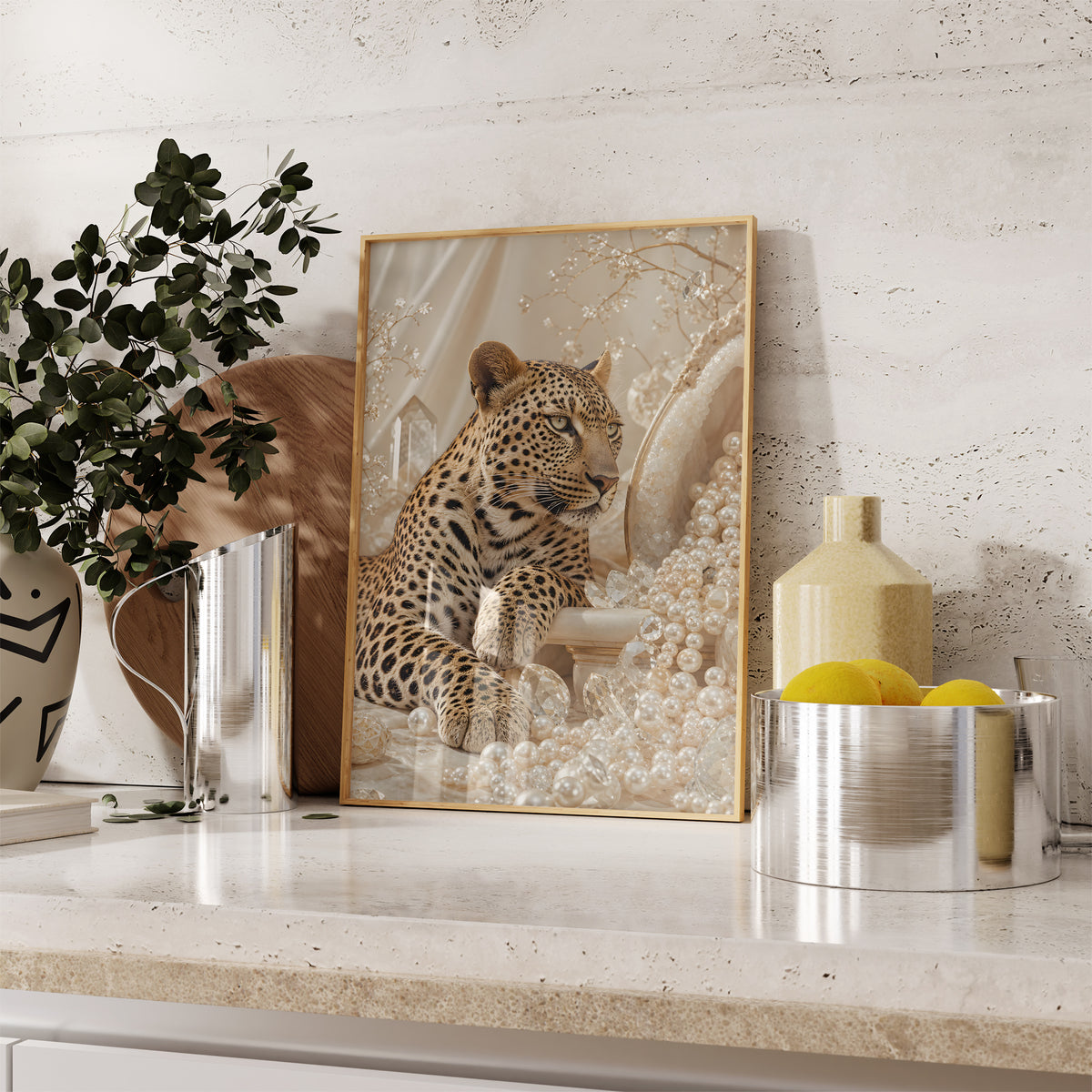 Gerahmtes Poster mit einem Leoparden zwischen cremefarbenen Perlen und goldenen Zweigen, auf einer Küchenarbeitsplatte neben Pflanzen und Zitronen.