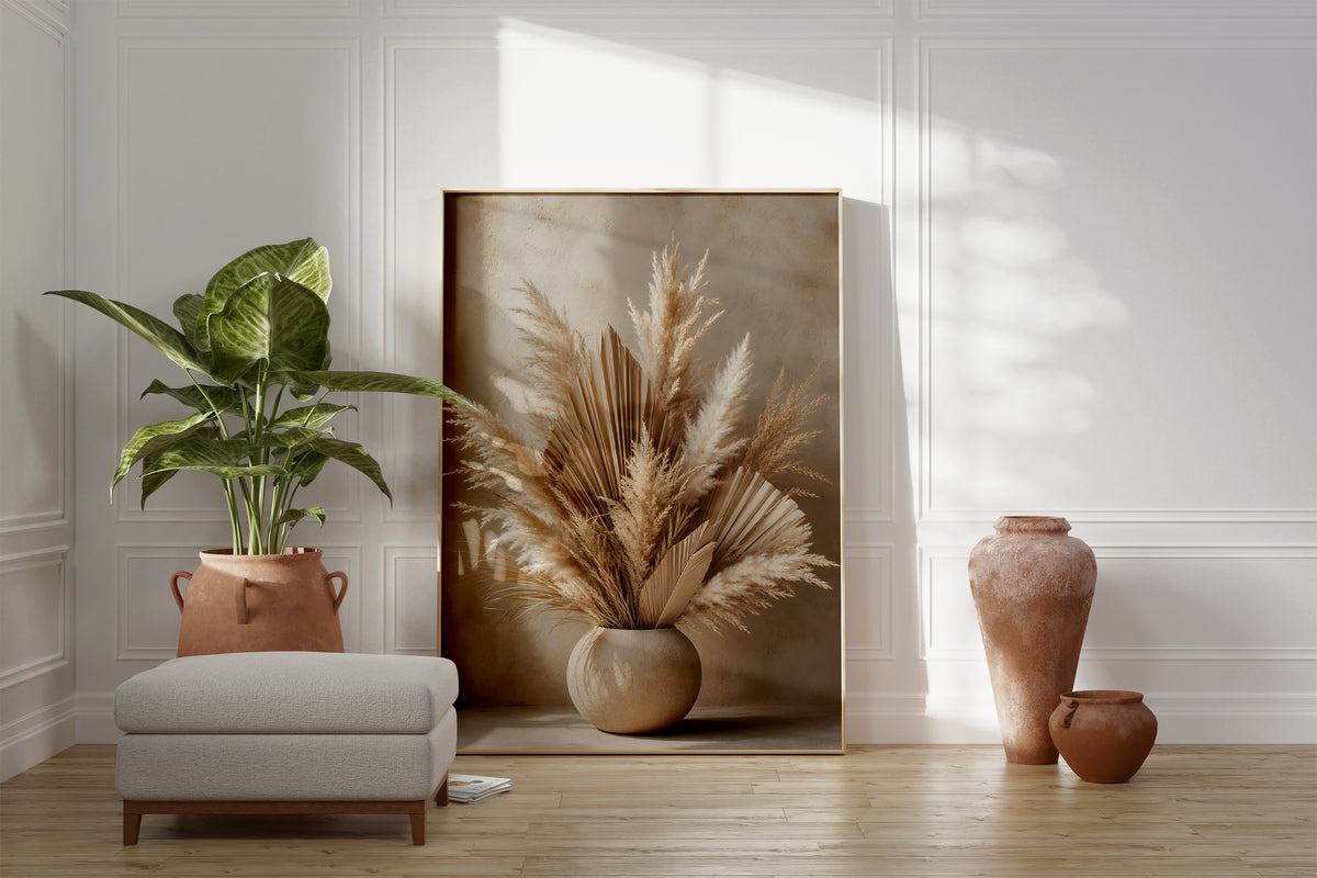 Motiv mit Pampaswedeln und getrockneten Palmfächern in einer runden beigen Vase, als gerahmtes Poster neben Sessel und Zimmerpflanze.