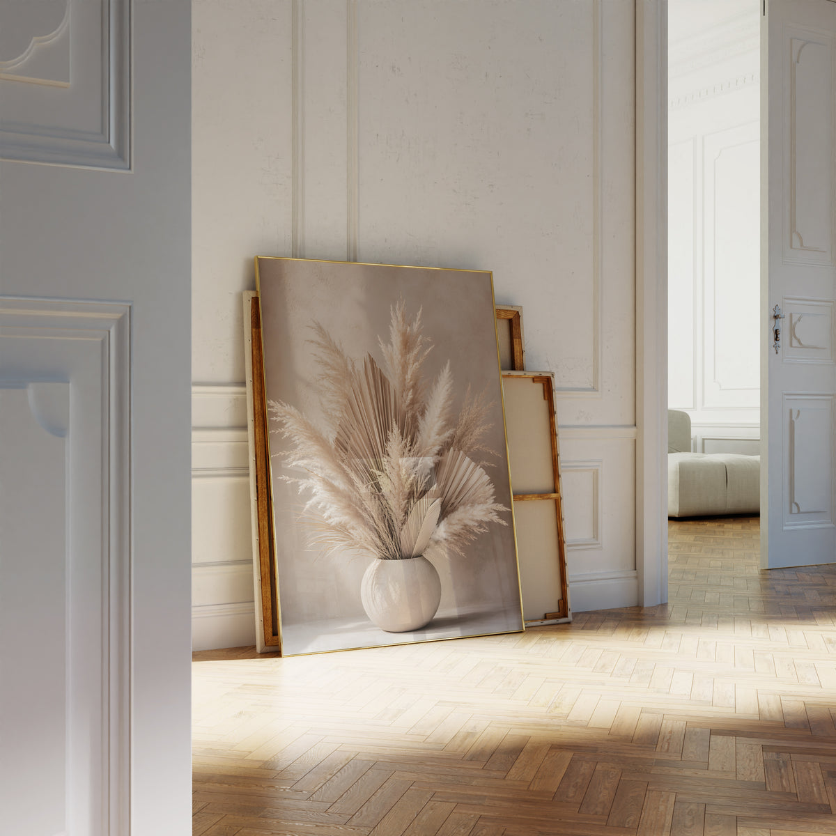 Motiv mit Pampaswedeln und getrockneten Palmfächern in einer runden beigen Vase, als an die Wand gelehntes Poster neben leeren Rahmen.