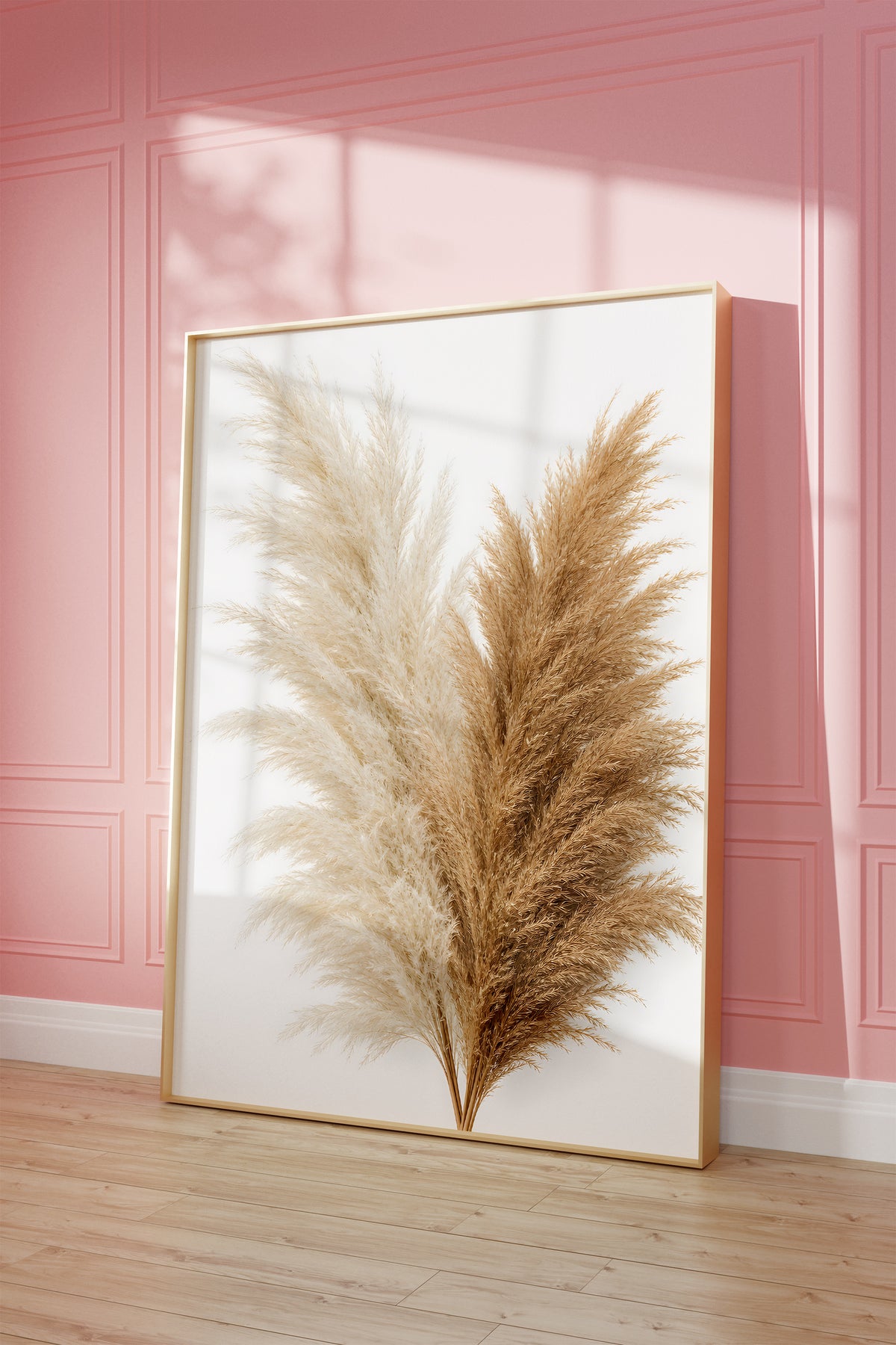 Motiv mit einem Bouquet aus cremeweißen und naturbraunen Pampaswedeln vor weißem Hintergrund, als gerahmtes Poster vor einer rosafarbenen Wand.