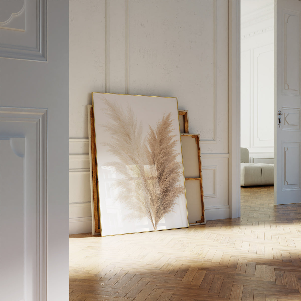 Motiv mit einem Bouquet aus cremeweißen und naturbraunen Pampaswedeln vor weißem Hintergrund, als an die Wand gelehntes Poster neben leeren Rahmen.