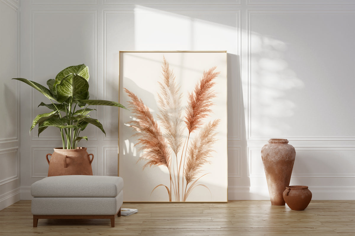 Motiv mit einem illustrierten Pampasbouquet in Rosé und Creme, als gerahmtes Poster neben Sessel und Zimmerpflanze.
