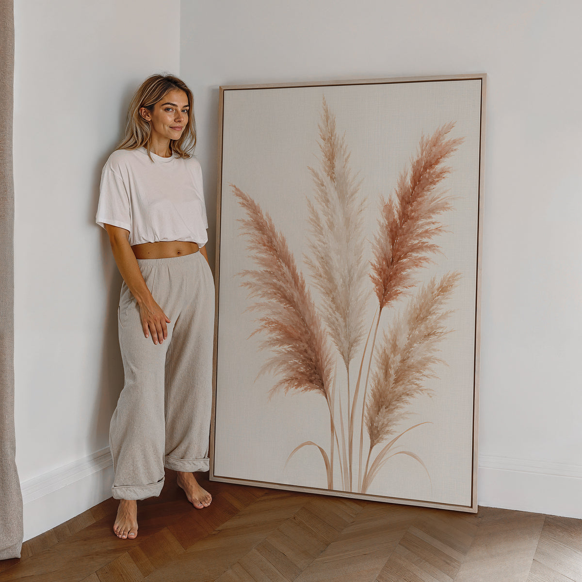 Motiv mit einem illustrierten Pampasbouquet in Rosé und Creme, als großes gerahmtes Wandbild neben einer Frau.