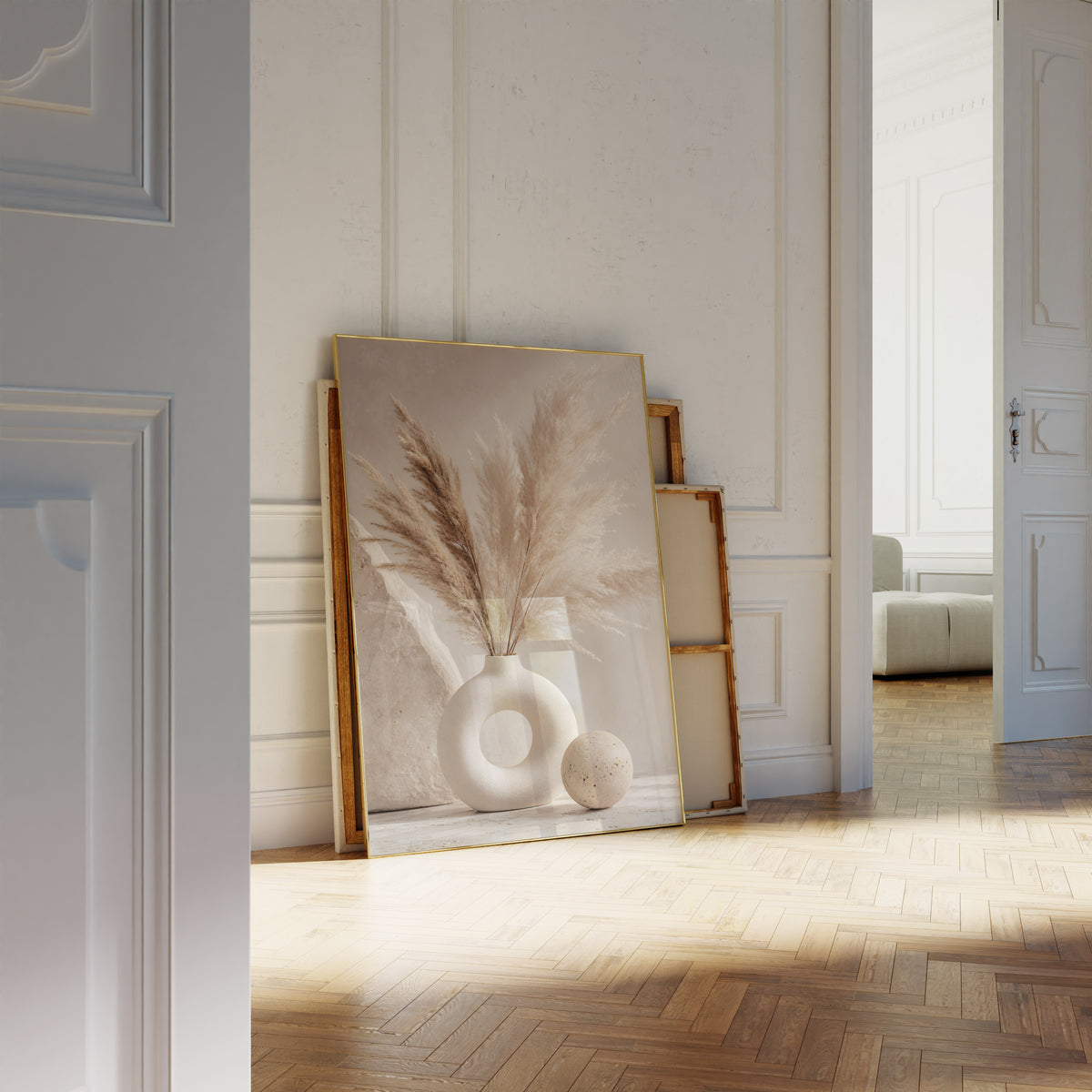 Motiv mit einem cremebraunen Pampasbouquet in einer weißen Ringvase neben einer Steinkugel, als an die Wand gelehntes Poster neben leeren Rahmen.