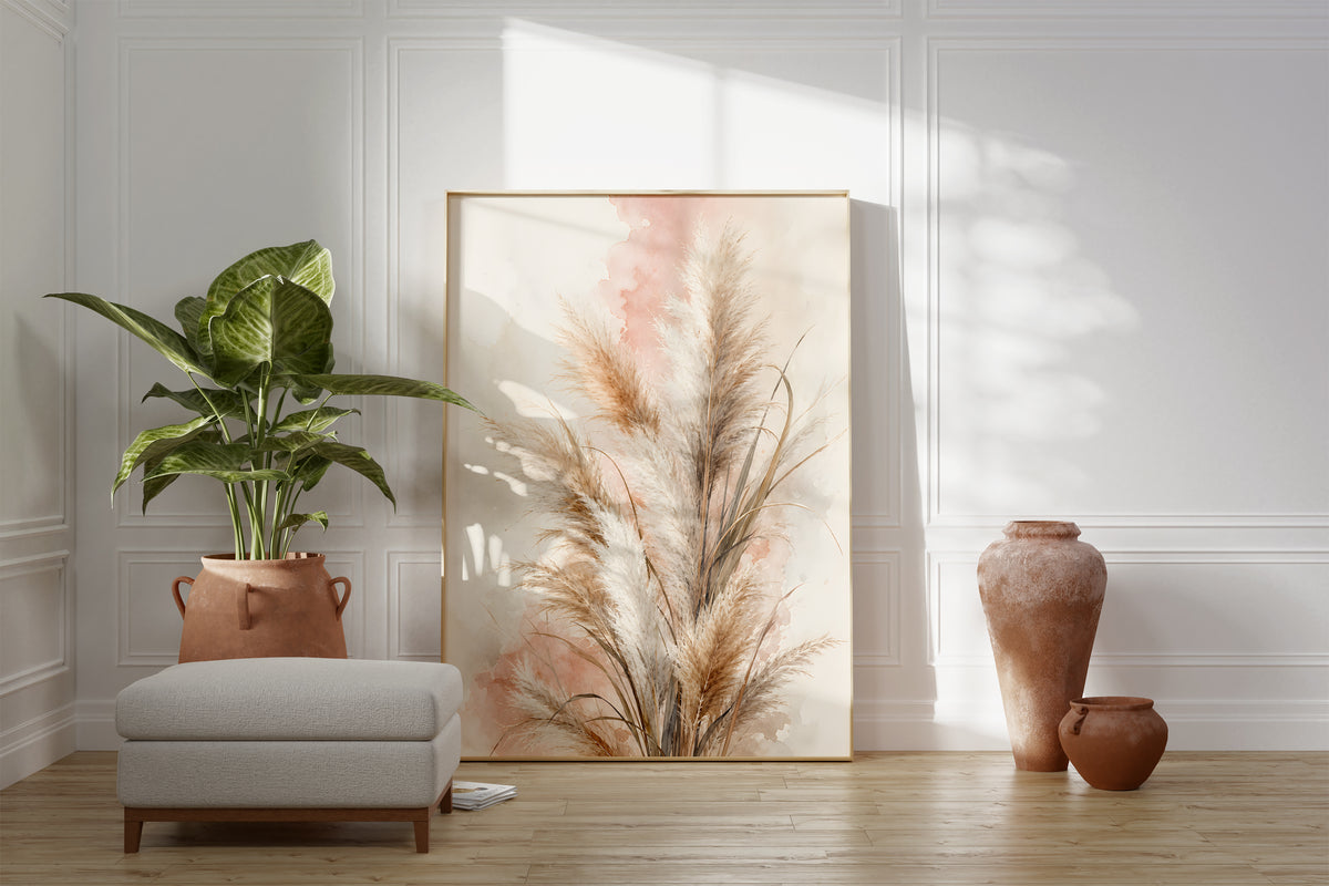 Motiv mit beigebraunen Pampasgräsern vor rosigen Aquarellflächen, als gerahmtes Poster neben Sessel und Zimmerpflanze.