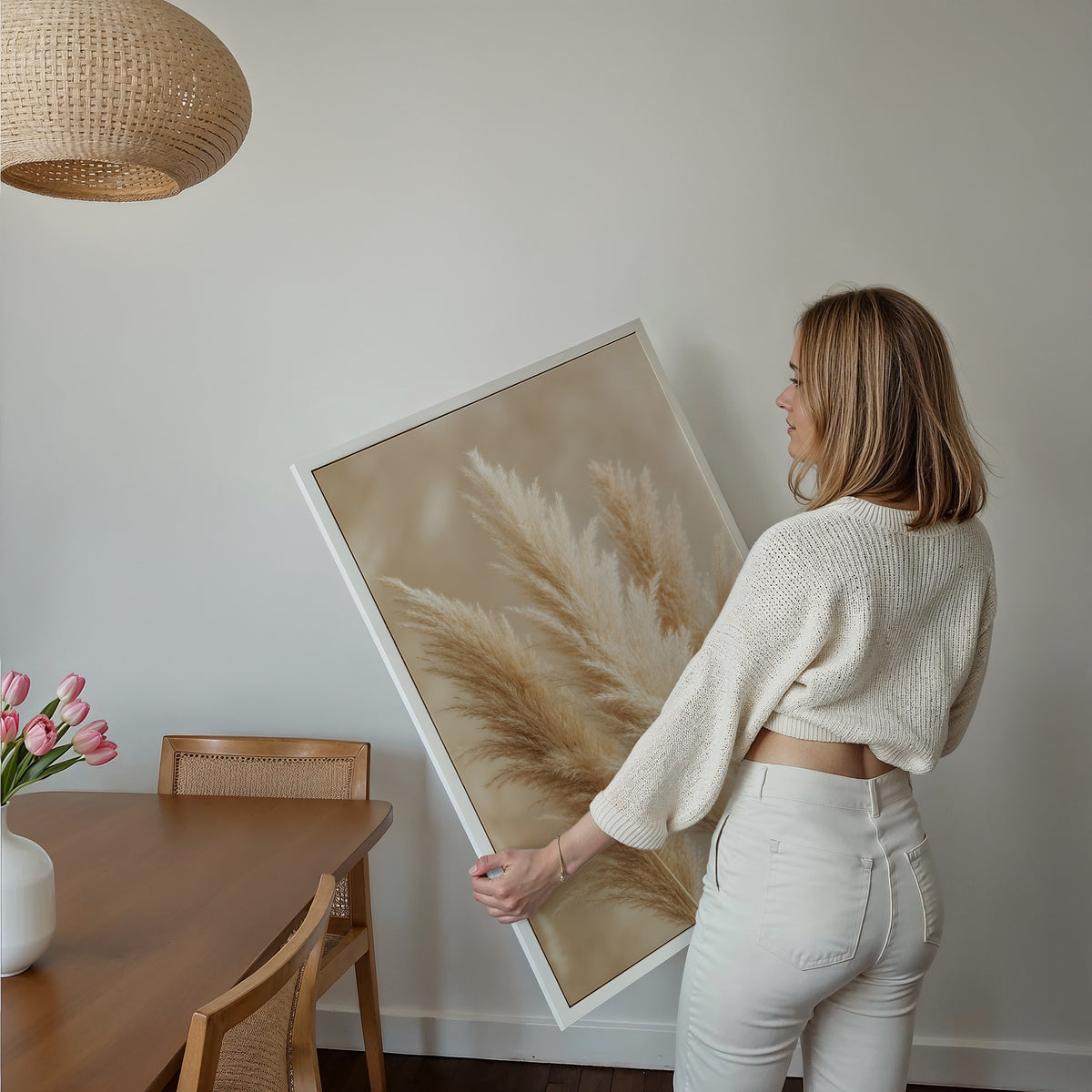 Motiv mit mehreren flauschigen Pampaswedeln in Creme und Beige vor weich verschwommenem Hintergrund, über einem Bett im hellen Schlafzimmer.